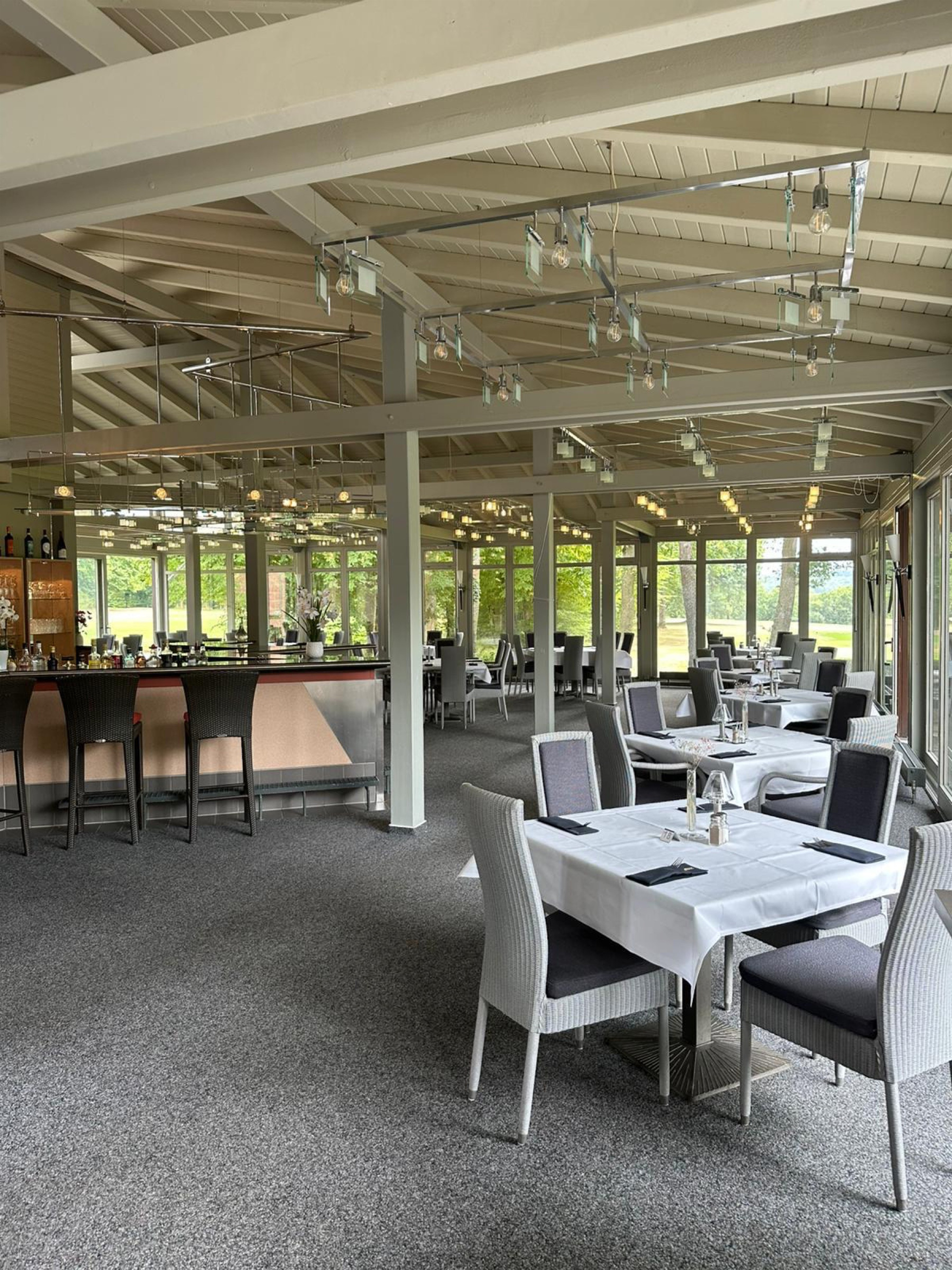Innenraum des Restaurants mit Bar und gedeckten Tischen