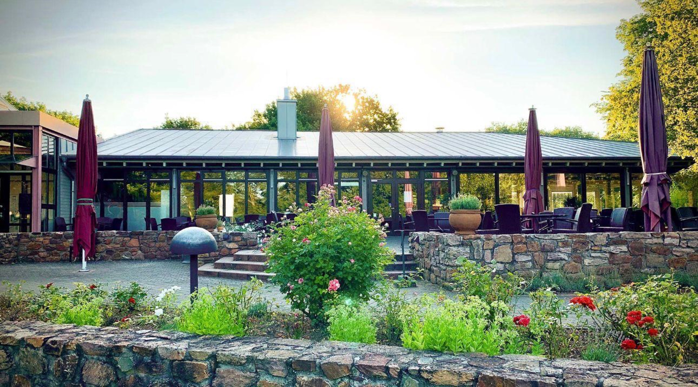Terrasse des Restaurants mit Steinmauer und Blumen